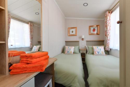 a bedroom with two twin beds with orange blankets at Cludfan in Abersoch