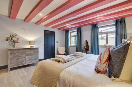 a bedroom with a large bed with a red ceiling at The Barn in Croyde