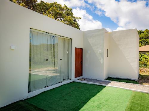 a room with glass doors and a green lawn at Casa Mirafeliz in Fernando de Noronha