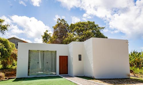a white house with a door and a yard at Casa Mirafeliz in Fernando de Noronha
