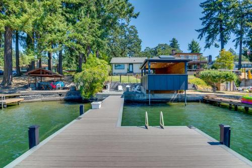 a wooden dock with a house on the water at Waterfront Gem with Boat Dock and Lift in Lakewood! in Lakewood