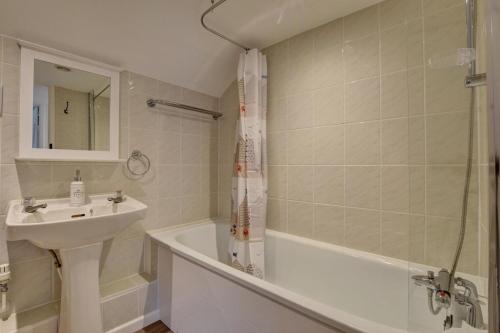 a bathroom with a sink and a tub and a shower at The Cottage in Trentishoe