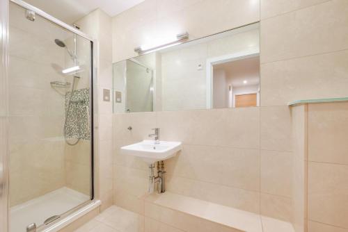 Un baño con lavabo, ducha y espejo. en 10 Ocean Point, en Croyde