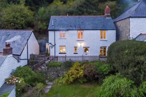 a white house with a fence in front of it at Tree Tops Lynbridge in Lynmouth
