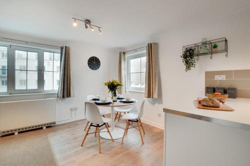 ウーラクームにあるBeach Escapeのテーブルと椅子のあるキッチンとダイニングルーム