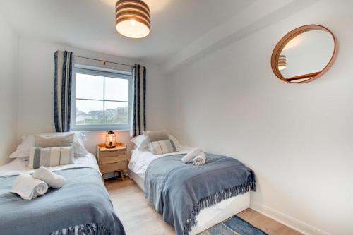 ウーラクームにあるBeach Escapeの鏡と窓付きの部屋のベッド2台