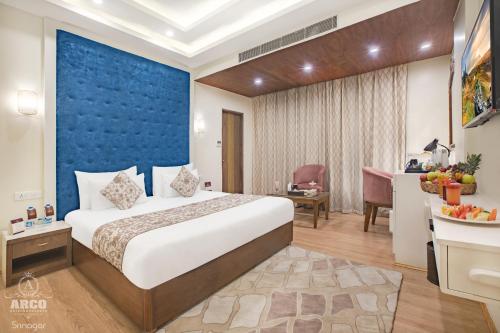 a hotel room with a bed and a desk at ARCO Hotels and Resorts Srinagar in Srinagar
