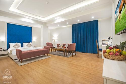 a hotel room with a bed and a table and chairs at ARCO Hotels and Resorts Srinagar in Srinagar