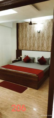 a bedroom with a large bed with red pillows at Hotel Green view with mountain view in Dharampur