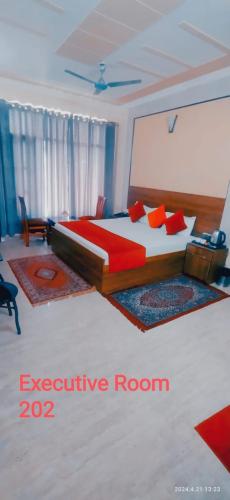 a bedroom with a large bed with red pillows at Hotel Green view with mountain view in Dharampur