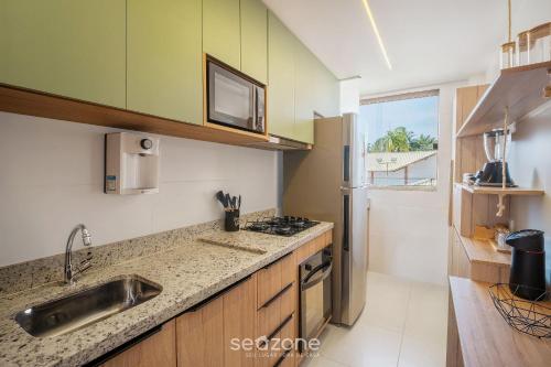 a kitchen with a sink and a counter top at Apto Charmoso com Vista para Piscina! - BIO0079 in Camaçari
