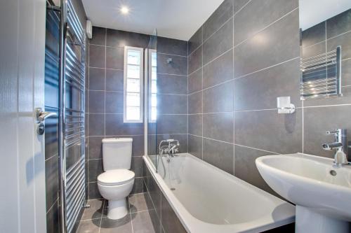 a bathroom with a toilet and a sink and a bath tub at Flat 1 Holmesdale in Carbis Bay