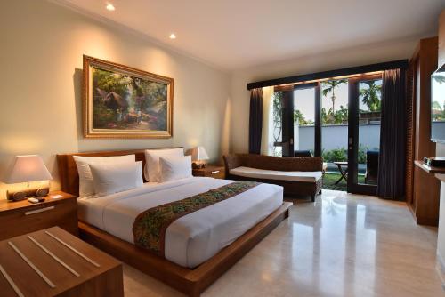 Un dormitorio con una cama grande y una sala de estar. en Ubud Wana Villa, en Ubud