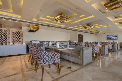 a restaurant with tables and chairs in a room at ARCO Hotels and Resorts Srinagar in Srinagar