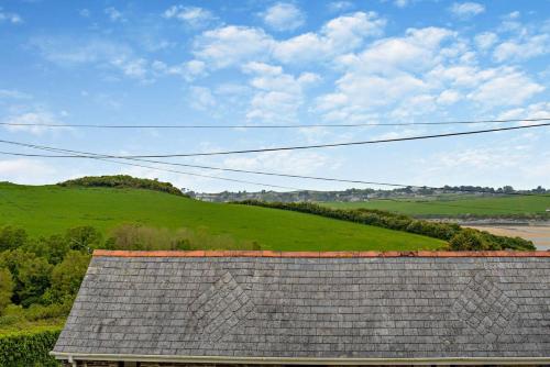 a roof of a house with a green hill in the background at Trailside in Saint Issey