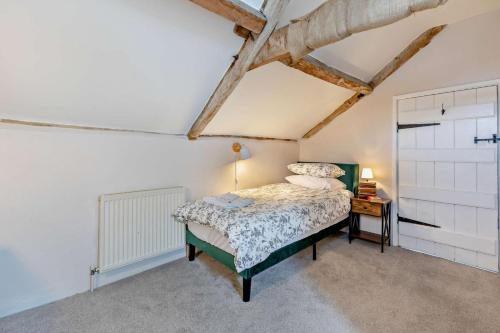 a bedroom with a bed and a table with a lamp at Ivy Leaf Farm Barn in Somerton