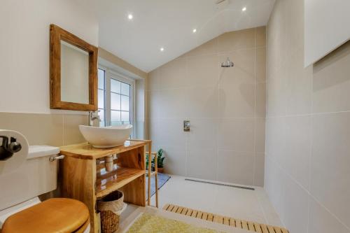 un baño con lavabo y espejo en Quercus Cottage - Challock, en Leaveland