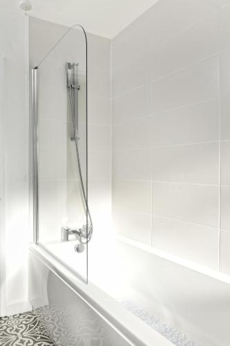 a white bathroom with a tub and a sink at 20 Cae Du in Abersoch
