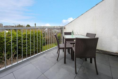 a patio with a table and chairs on a balcony at 20 Cae Du in Abersoch