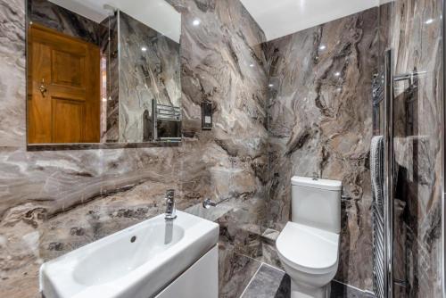 une salle de bains avec lavabo, toilettes et miroir dans l'établissement Otter Cottage at West Ashridge, à Bideford