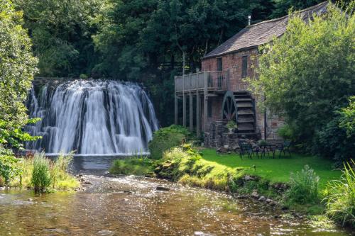 a waterfall in front of a building with a waterfall at Mount Pleasant in Tebay