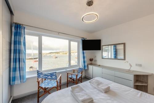 Un dormitorio con una cama y vista al mar. en Saltwhistle View, en Teignmouth