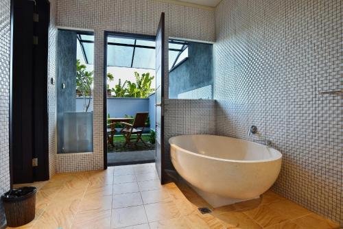 Un baño con una bañera grande en una habitación. en Ubud Wana Villa, en Ubud