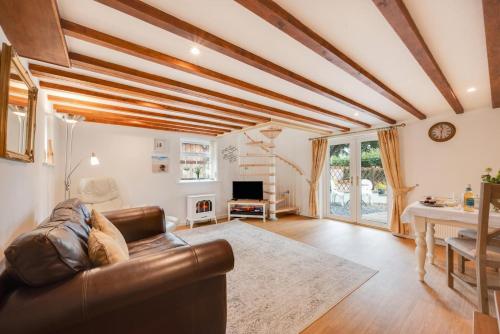 a living room with a leather couch and a table at Thyme at South Worden in Bulkworthy