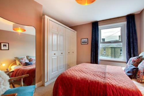 een slaapkamer met twee bedden en een raam bij Jackdaw Cottage in Embsay