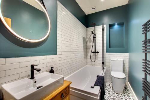 een badkamer met een wastafel, een bad en een toilet bij Jackdaw Cottage in Embsay