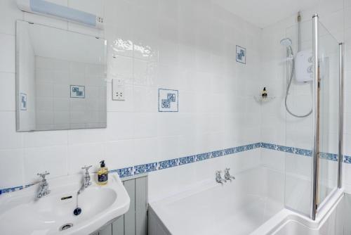 Un baño blanco con lavabo y ducha. en Y Felin, en Machynlleth