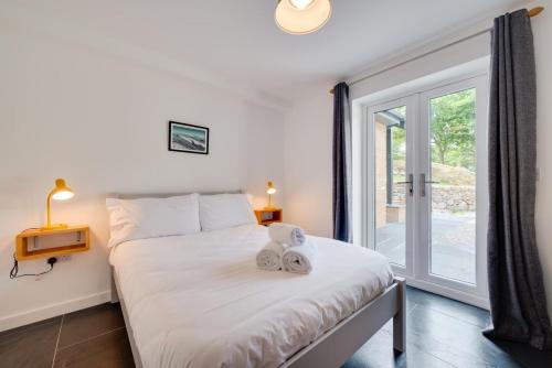 une chambre avec un lit et une grande fenêtre dans l'établissement Mor Mynydd, à Barmouth