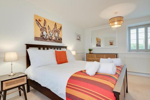 a bedroom with a large white bed and a table at Flora Belle Cottage in Sennen