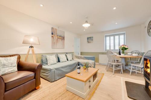 a living room with a couch and a table at Flora Belle Cottage in Sennen