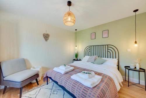 ein Schlafzimmer mit einem Bett und einem Stuhl in der Unterkunft Bryniau Pair Ucha Cottage in Gwytherin