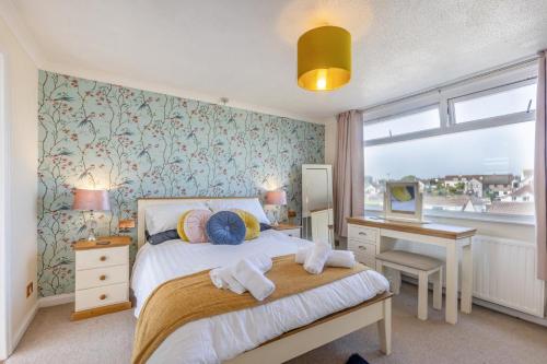 een slaapkamer met een bed, een bureau en een raam bij Soundwaves House in Bude