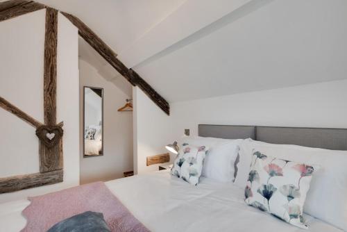 a bedroom with a bed with white sheets and pillows at Cuddfan Idris in Dolgellau