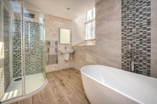 a bathroom with a tub and a toilet and a sink at St Aelrhiws Church in Rhiw