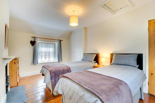 a bedroom with two beds and a window at Ty Newydd in Dolgellau