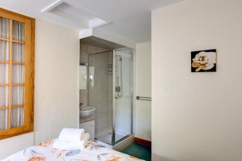 Zimmer mit einem Bett und einem Bad mit Dusche. in der Unterkunft East Cottage in Thwaite