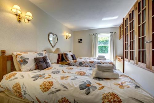 ein Schlafzimmer mit zwei Betten und einem großen Fenster in der Unterkunft East Cottage in Thwaite
