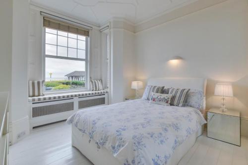 ein weißes Schlafzimmer mit einem Bett und einem Fenster in der Unterkunft Number 46 in Whitstable