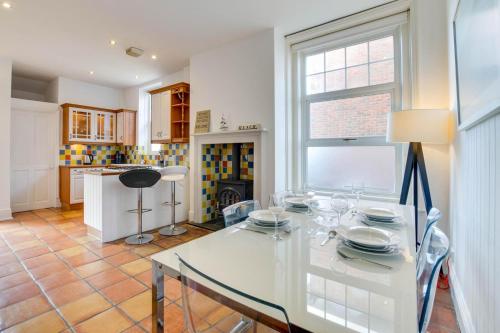 ein Esszimmer mit einem weißen Tisch und einer Küche in der Unterkunft Number 46 in Whitstable
