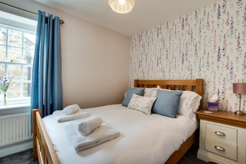 Un dormitorio con una cama con toallas. en Badgers Rest, en Grosmont