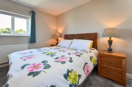 a bedroom with a bed and two lamps and a window at 16 Maes Gwydryn in Abersoch