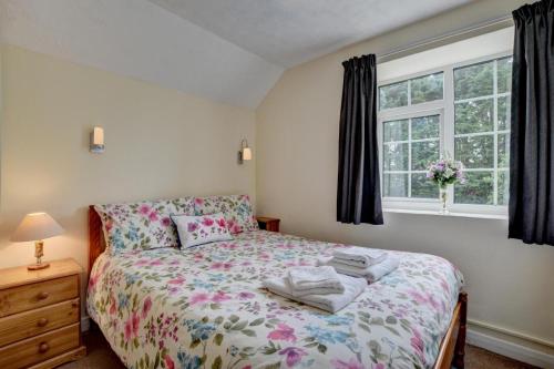 ein Schlafzimmer mit einem Bett und einem Fenster in der Unterkunft Pusehill Cottage in Westward Ho