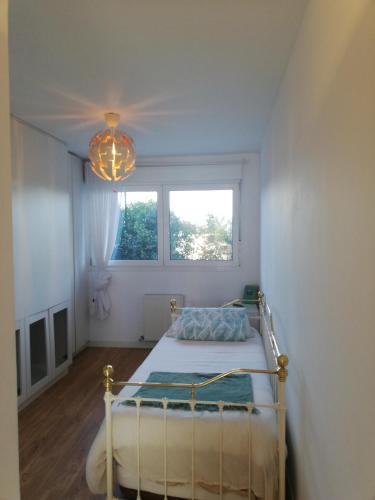 a bedroom with a bed and a window and a chandelier at Mar, playas y montañas in Miengo