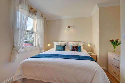 a bedroom with a large white bed with a window at Golden Beach in Woolacombe