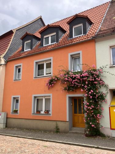 a orange house with flowers in front of it at Beim Stadttor in Belgern