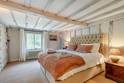 a bedroom with a large bed and a window at Corner Cottage - Kent in Benenden